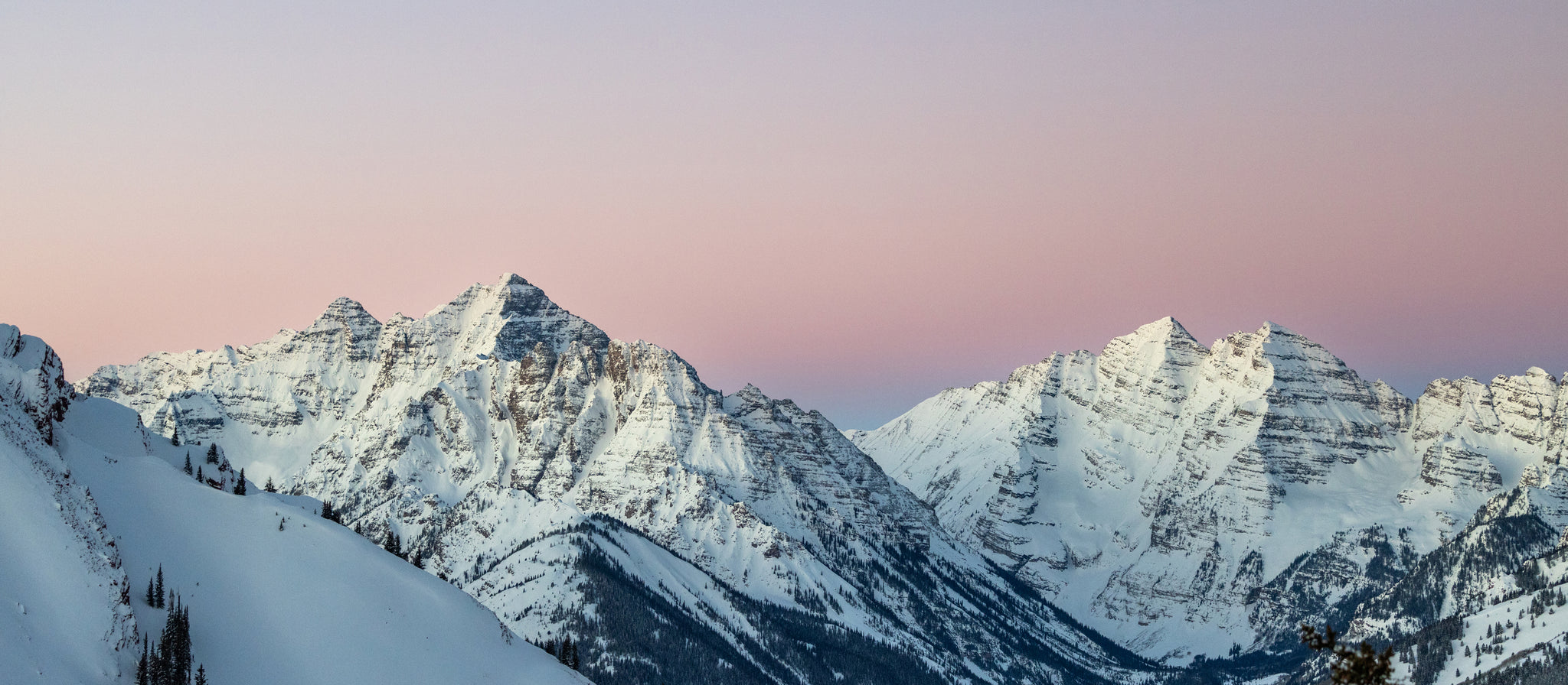 Snowy mountain range with a pinkish-purple sky
