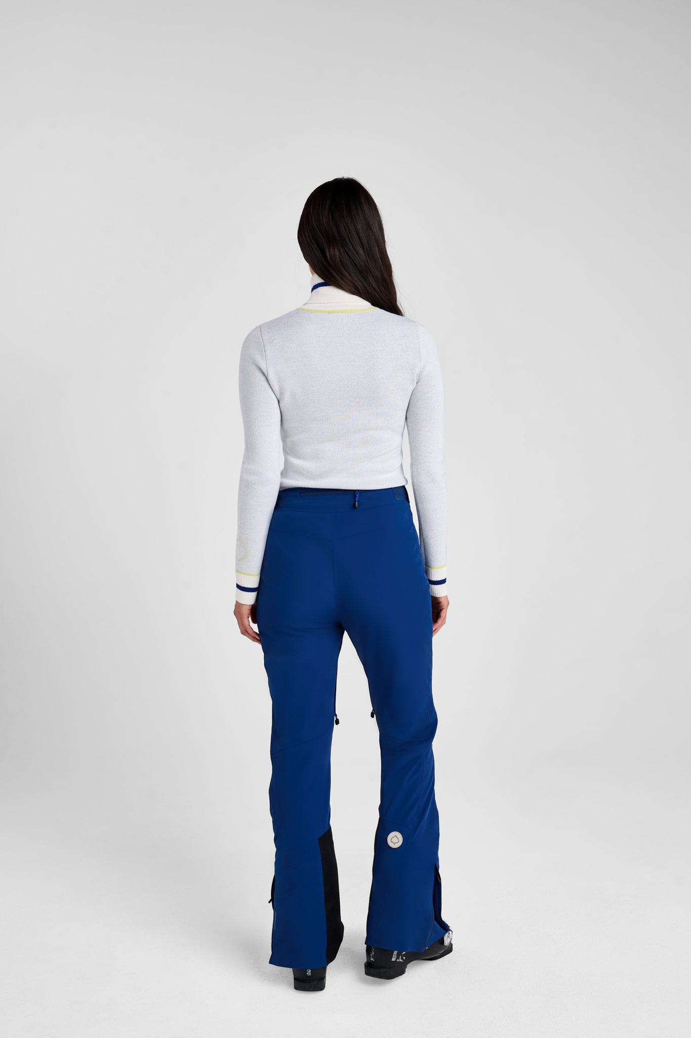 Person wearing a white top and blue pants on a white background