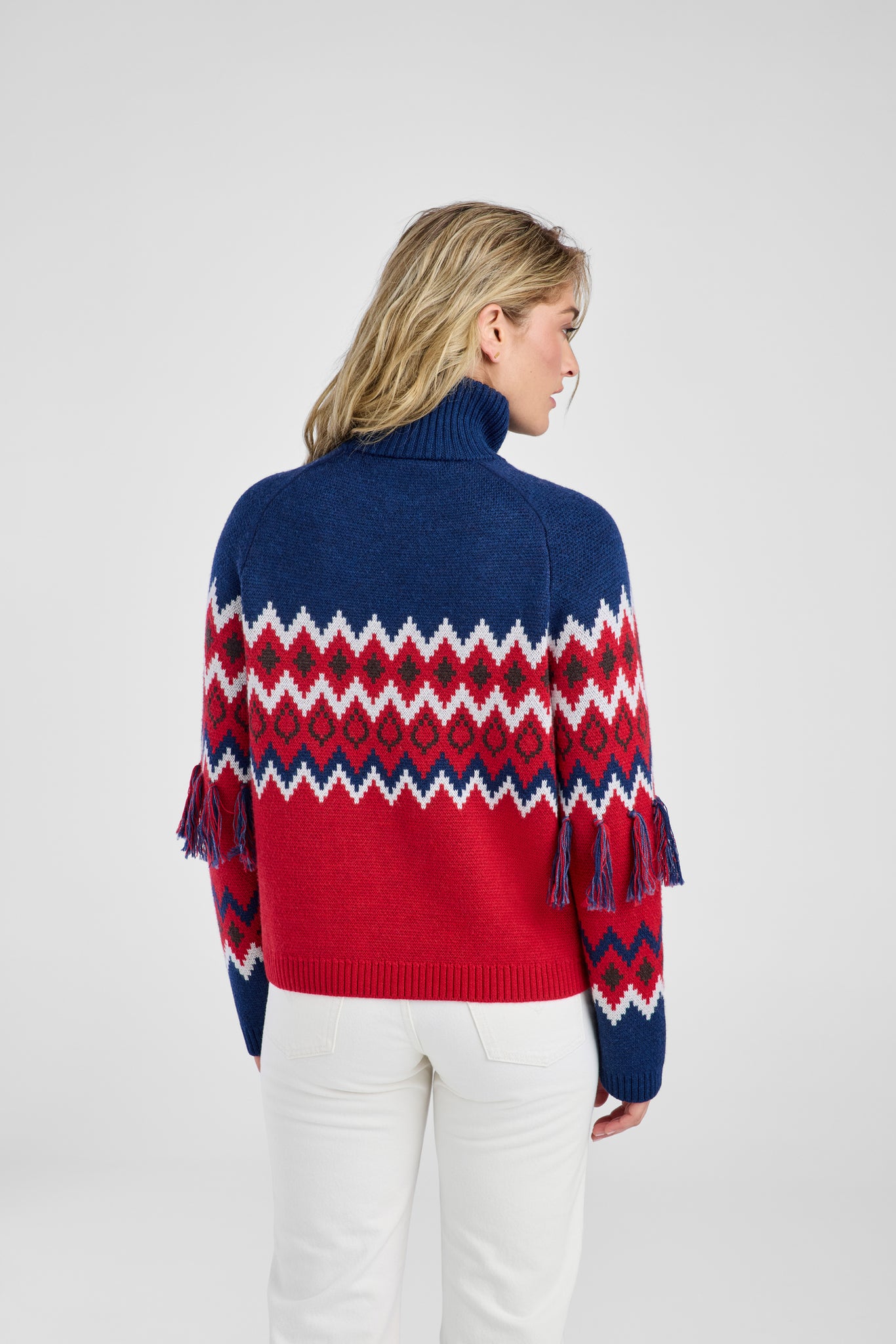Woman wearing a red, blue, and white patterned sweater on a white background
