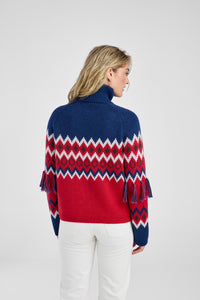 Woman wearing a red, blue, and white patterned sweater on a white background