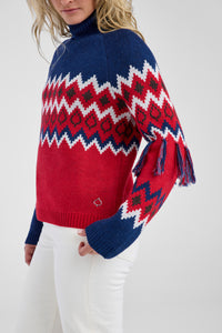 Woman wearing a red, blue, and white patterned sweater on a white background