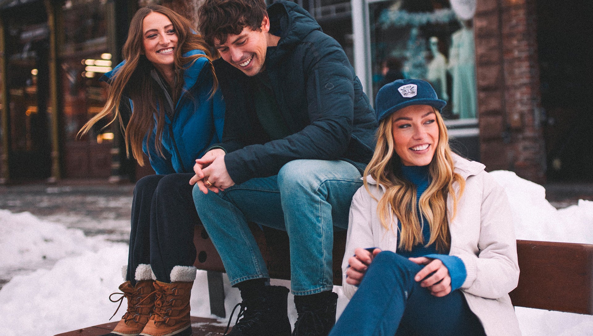 Three friends sitting together on a snowy day