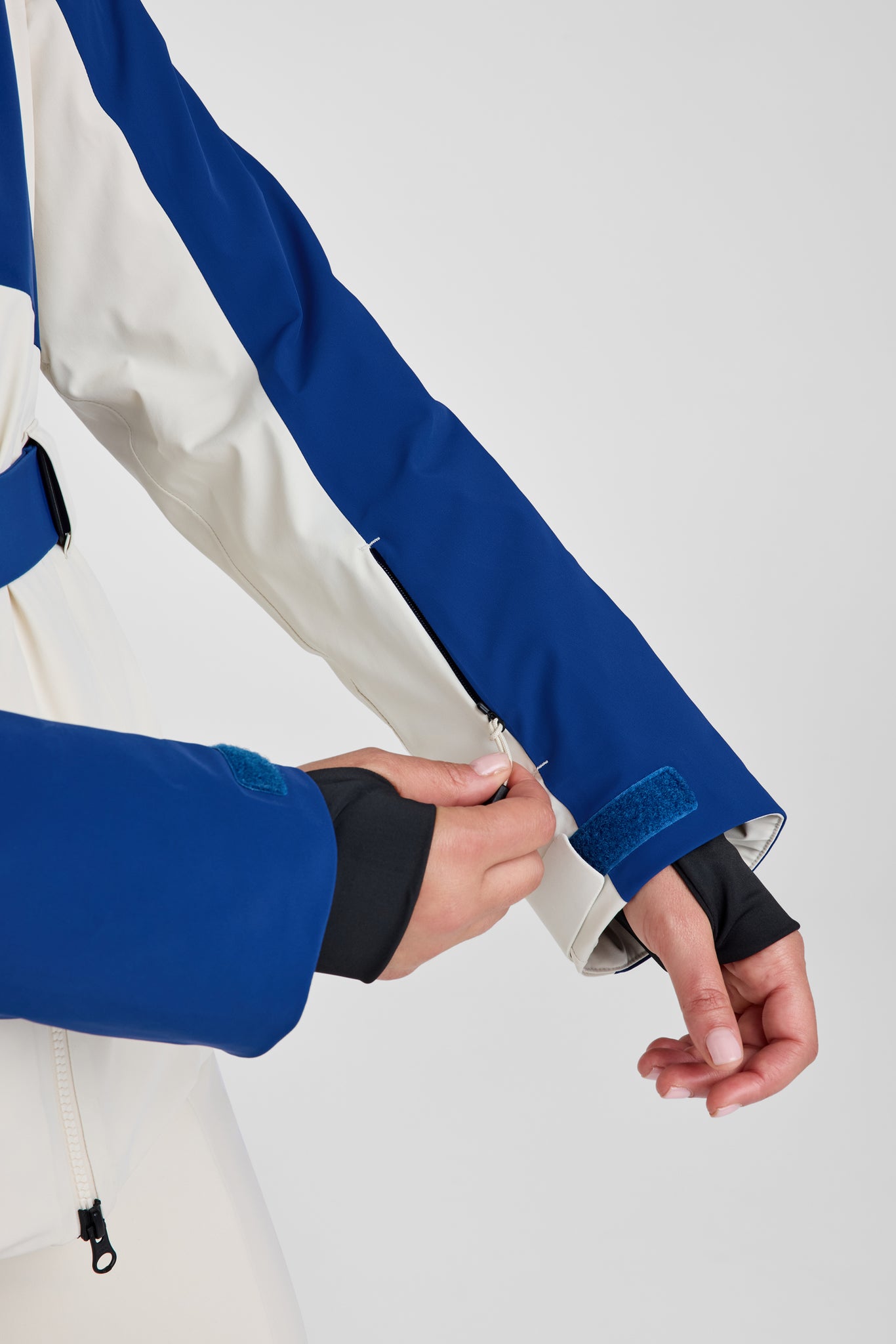 Person wearing a blue and white jacket on a light gray background