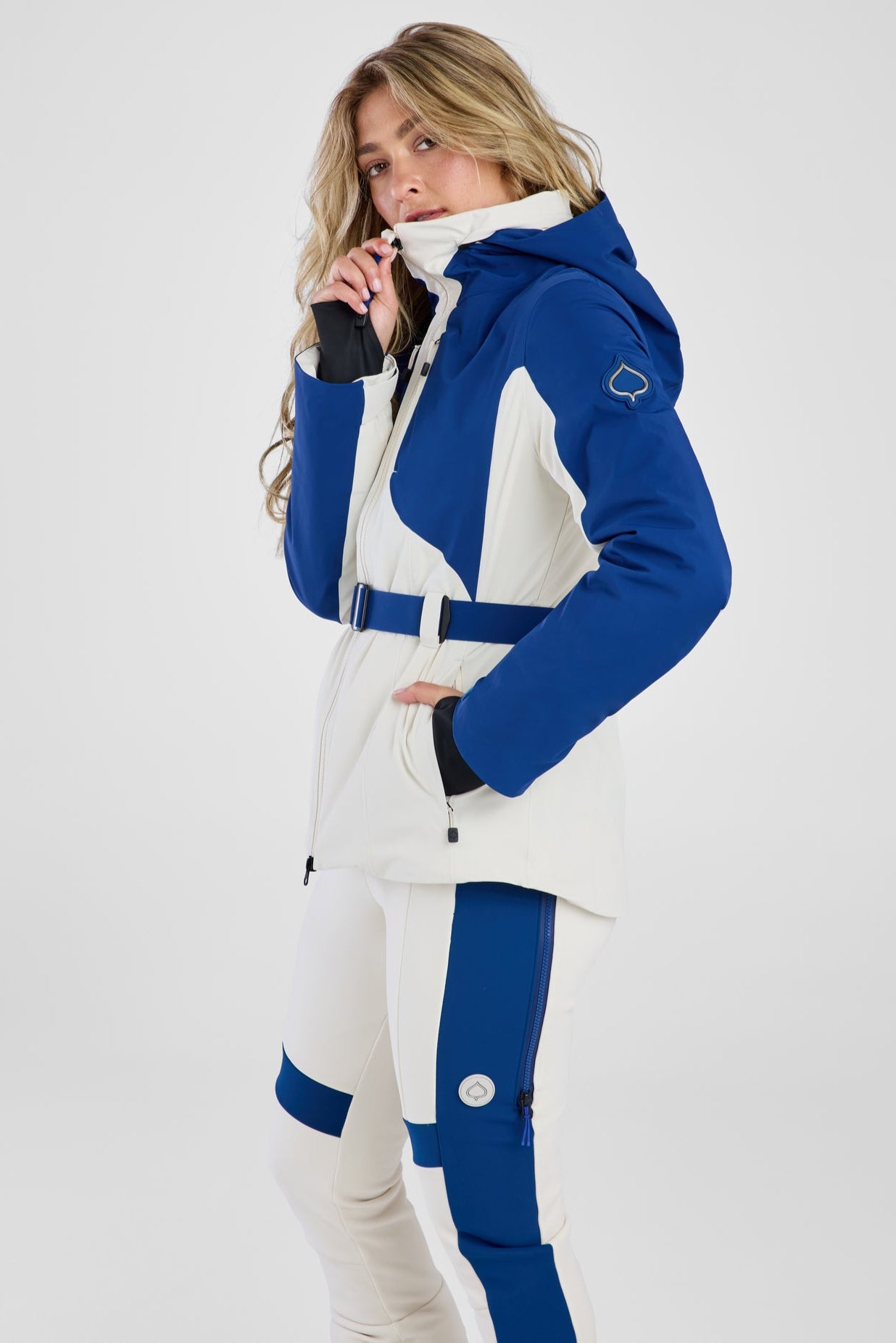 Woman wearing a blue and white ski suit on a white background