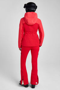 Person wearing a red ski suit and helmet on a gray background