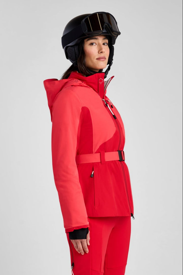 Person wearing a red ski suit and helmet on a gray background