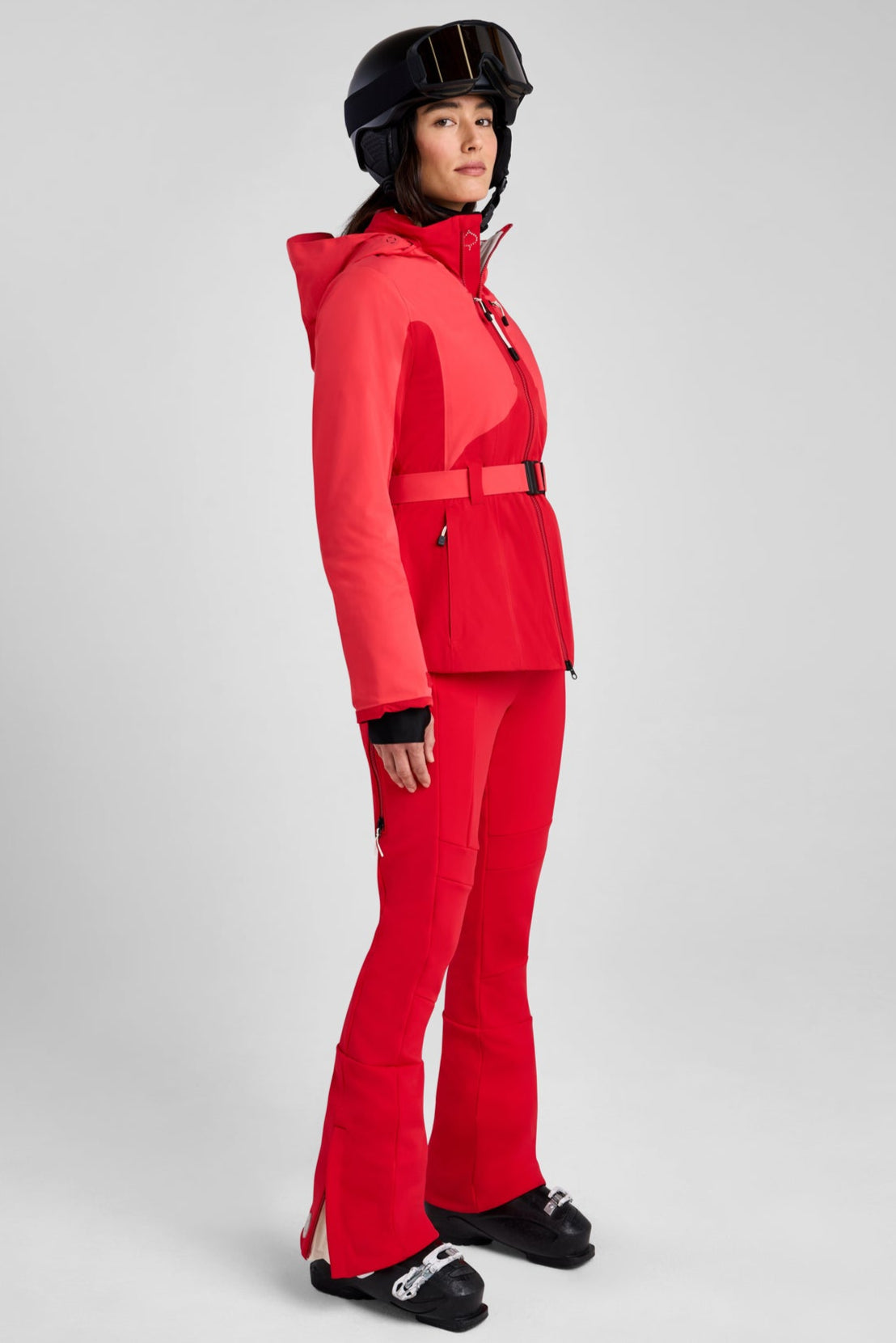 Person wearing a red ski suit and helmet on a gray background
