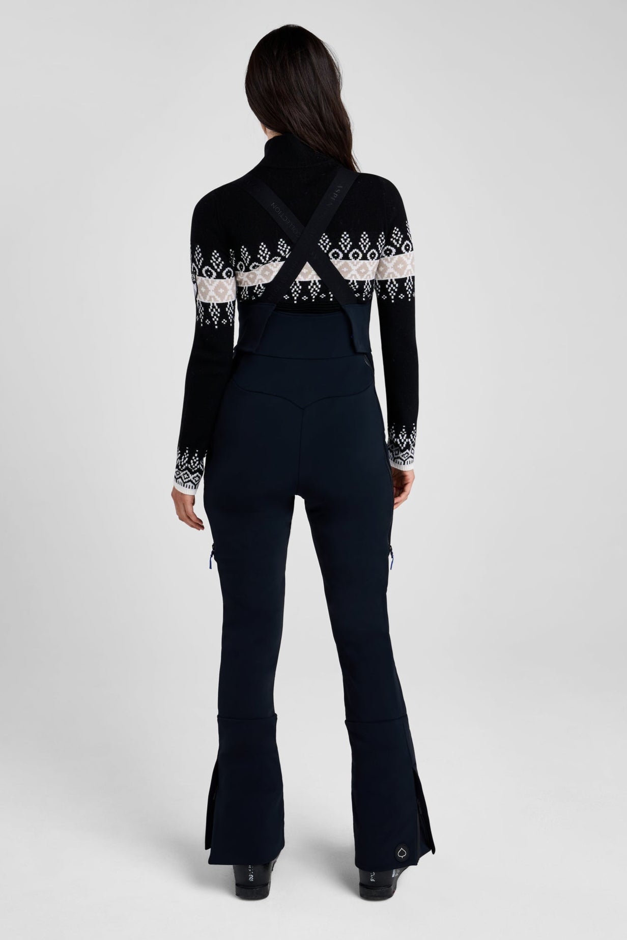 Person wearing a black outfit with white patterns on a white background
