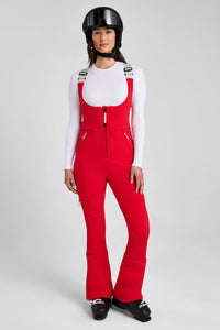 Person wearing a red ski suit and helmet on a gray background