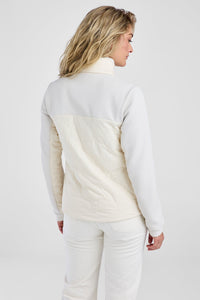 Woman wearing a white quilted jacket on a plain background