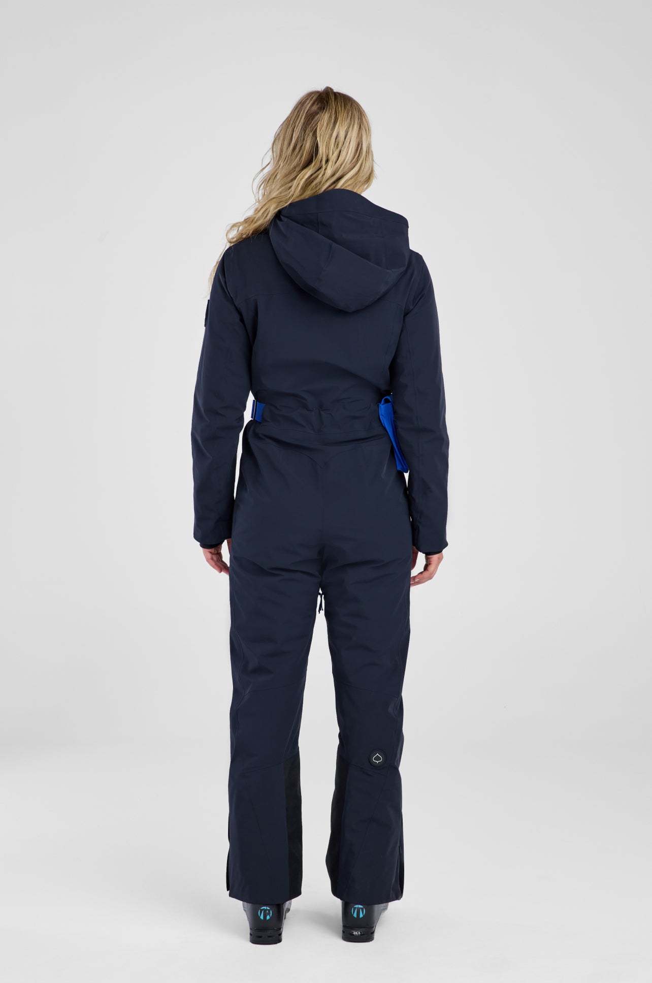 Person wearing a navy blue snowsuit on a white background