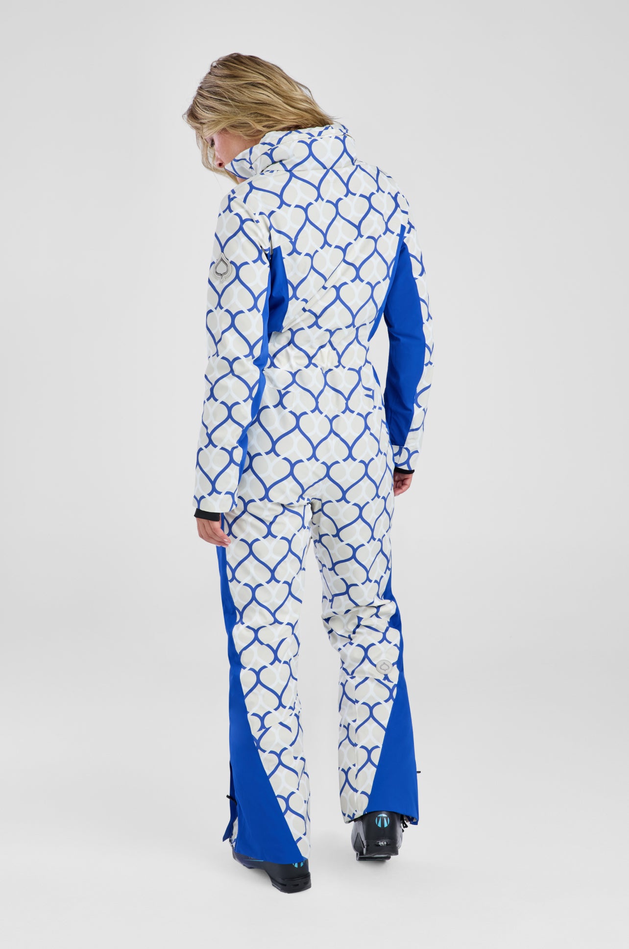 Person wearing a blue and white patterned snowsuit on a white background