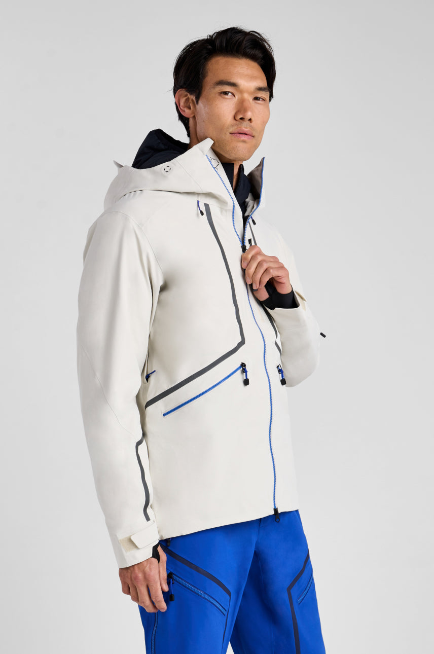 Person wearing a white jacket with blue accents on a light gray background