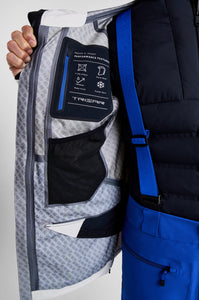 Close-up of a person holding a jacket with a visible brand label on a plain background