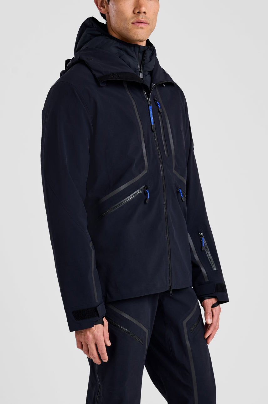 Person wearing a black jacket with blue zippers on a white background