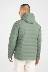 Person wearing a green puffer jacket on a white background