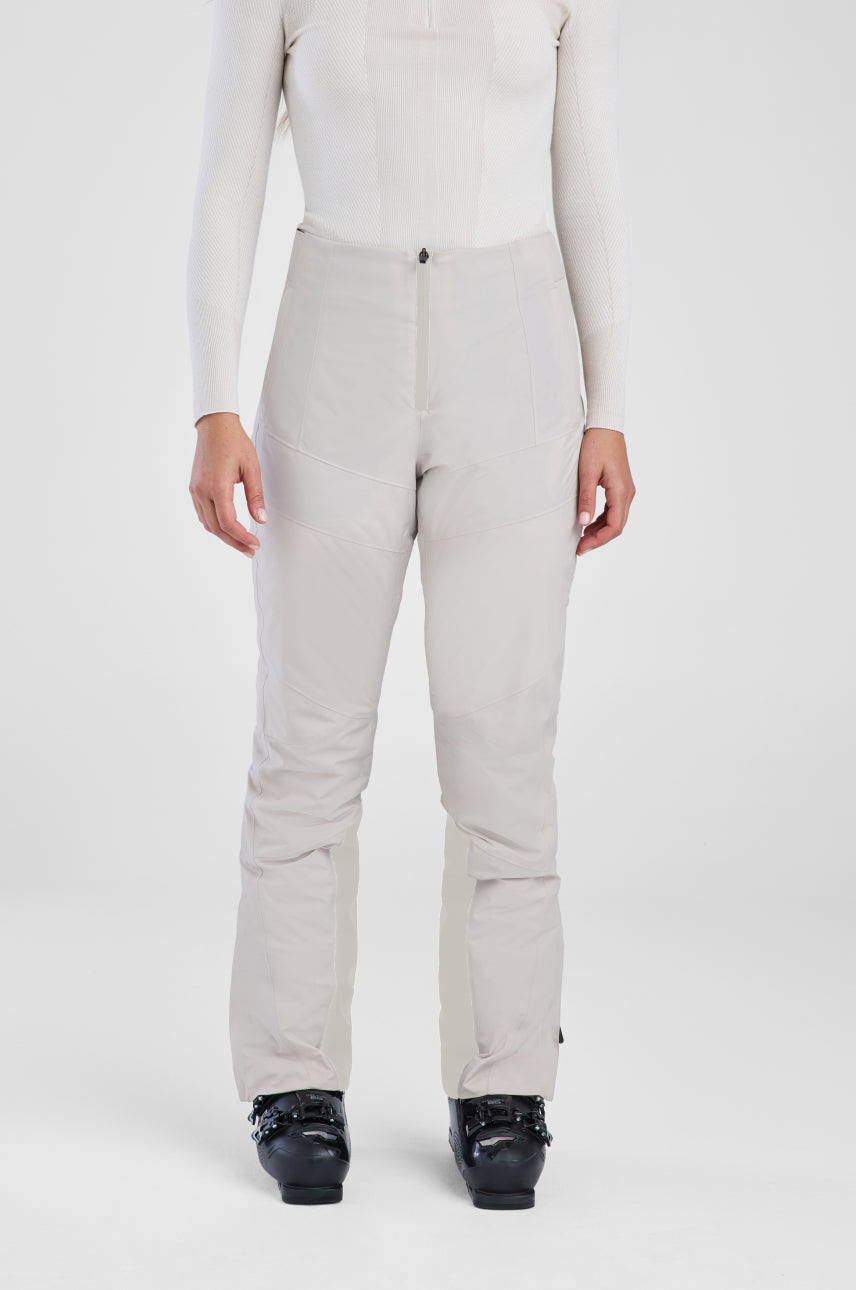 Person wearing beige pants and a white top on a white background