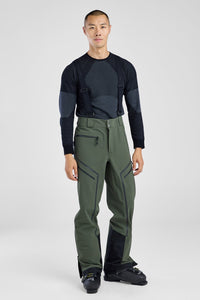 Person wearing a black long-sleeve shirt and green pants on a white background