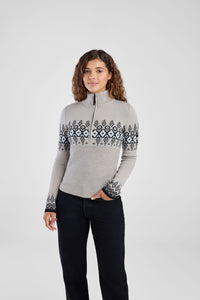 Woman wearing a gray sweater with a patterned design on a white background