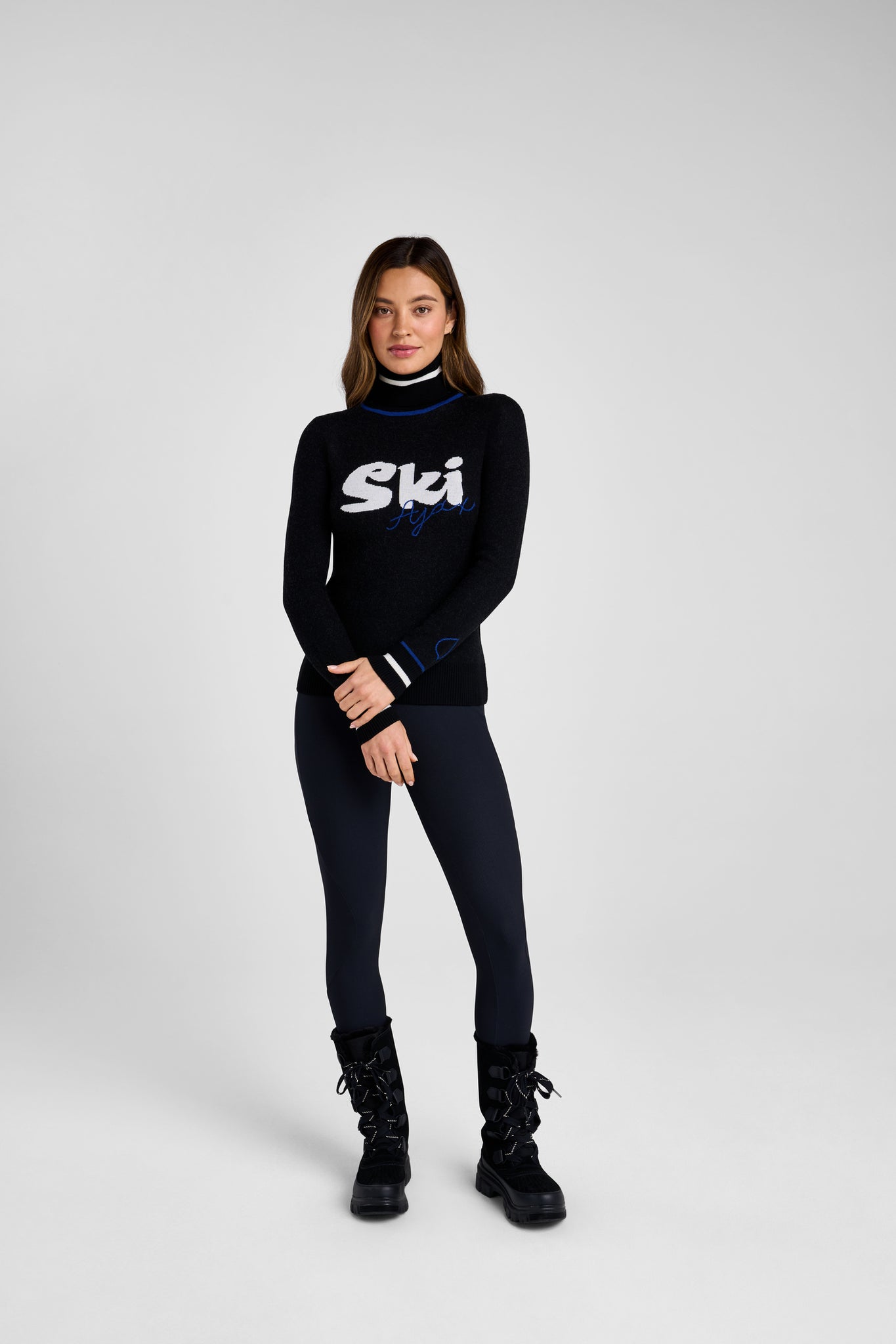 Woman wearing a black turtleneck with 'Ski' logo on a white background