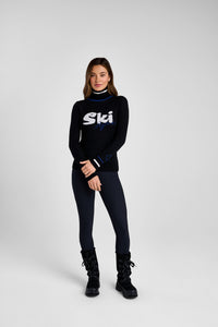 Woman wearing a black turtleneck with 'Ski' logo on a white background
