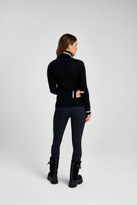 Woman wearing a black outfit with a high collar on a white background