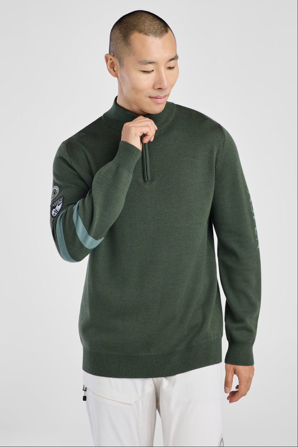 Man wearing a green sweater with a white background
