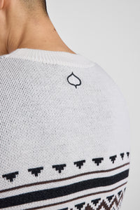Close-up of a black aspen leaf logo on a white sweater