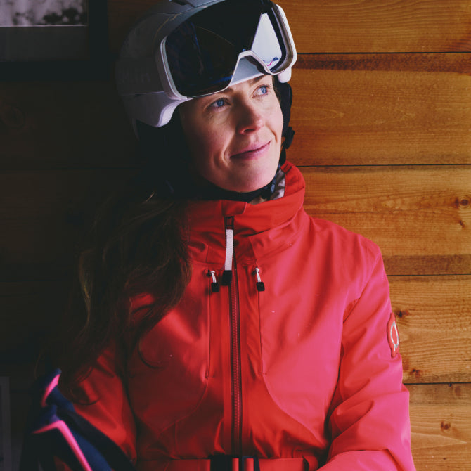 Person in a red ski suit with goggles on a wooden background