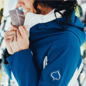 Person wearing a blue jacket with a leaf logo