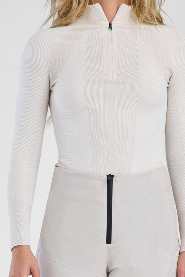 Person wearing a white ski suit with black accents on a white background