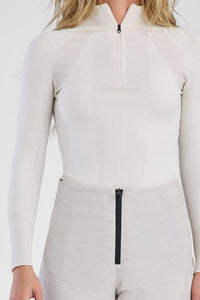 Person wearing a white ski suit with black accents on a white background