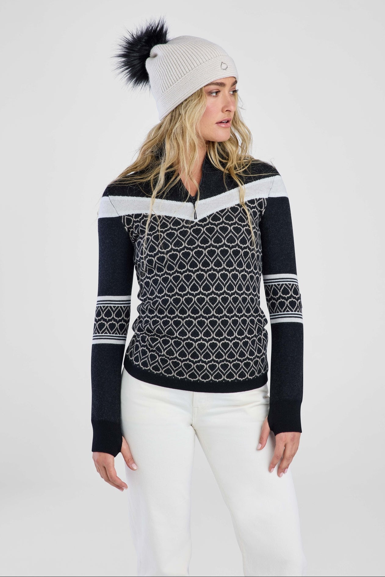 Women in black patterned sweater and grey pom beanie 