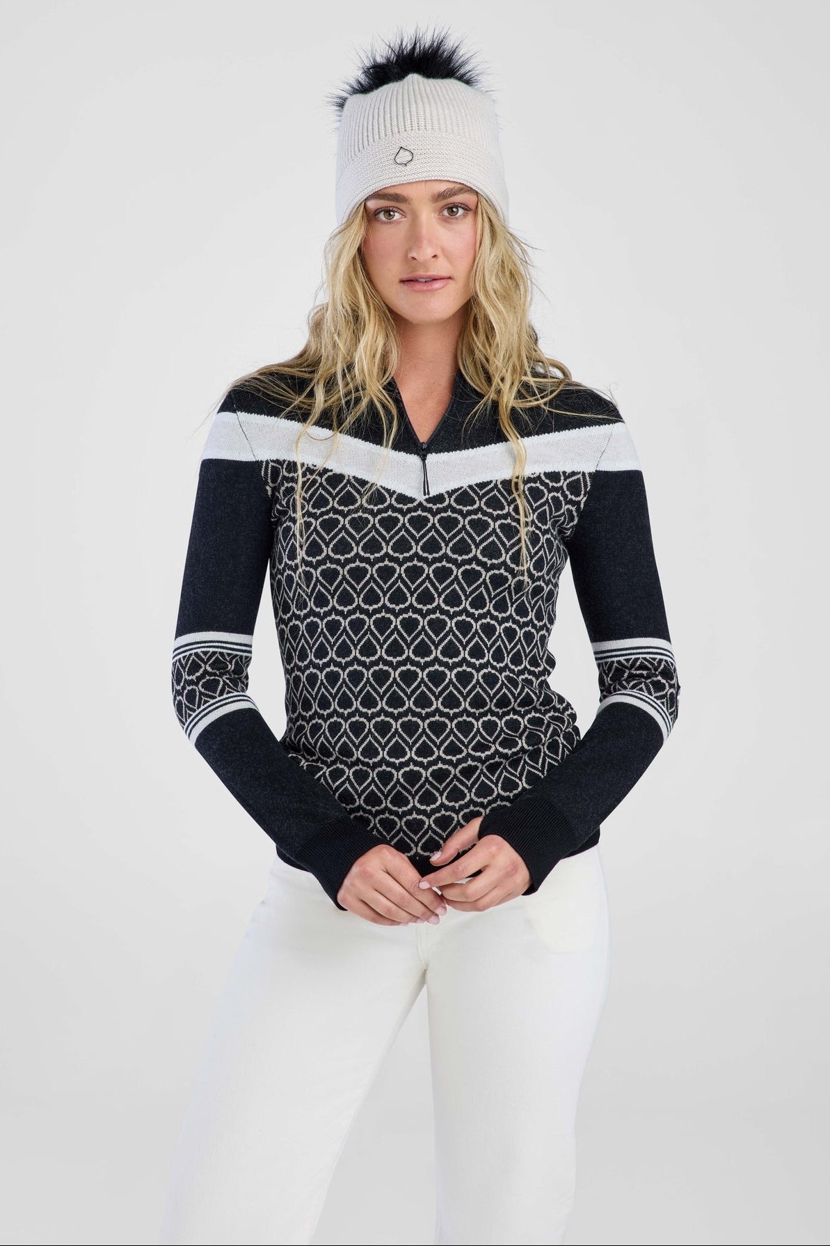 Women in black patterned sweater and grey pom beanie 