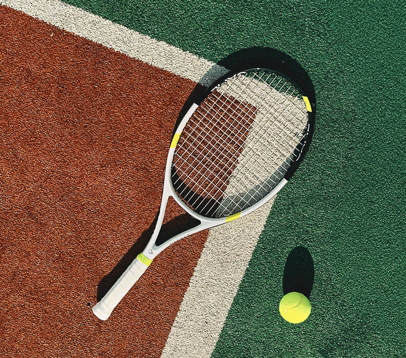 Tennis racket and ball on a tennis court surface