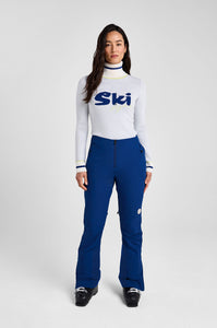 Person wearing a white ski sweater with 'Ski' logo and blue pants on a white background