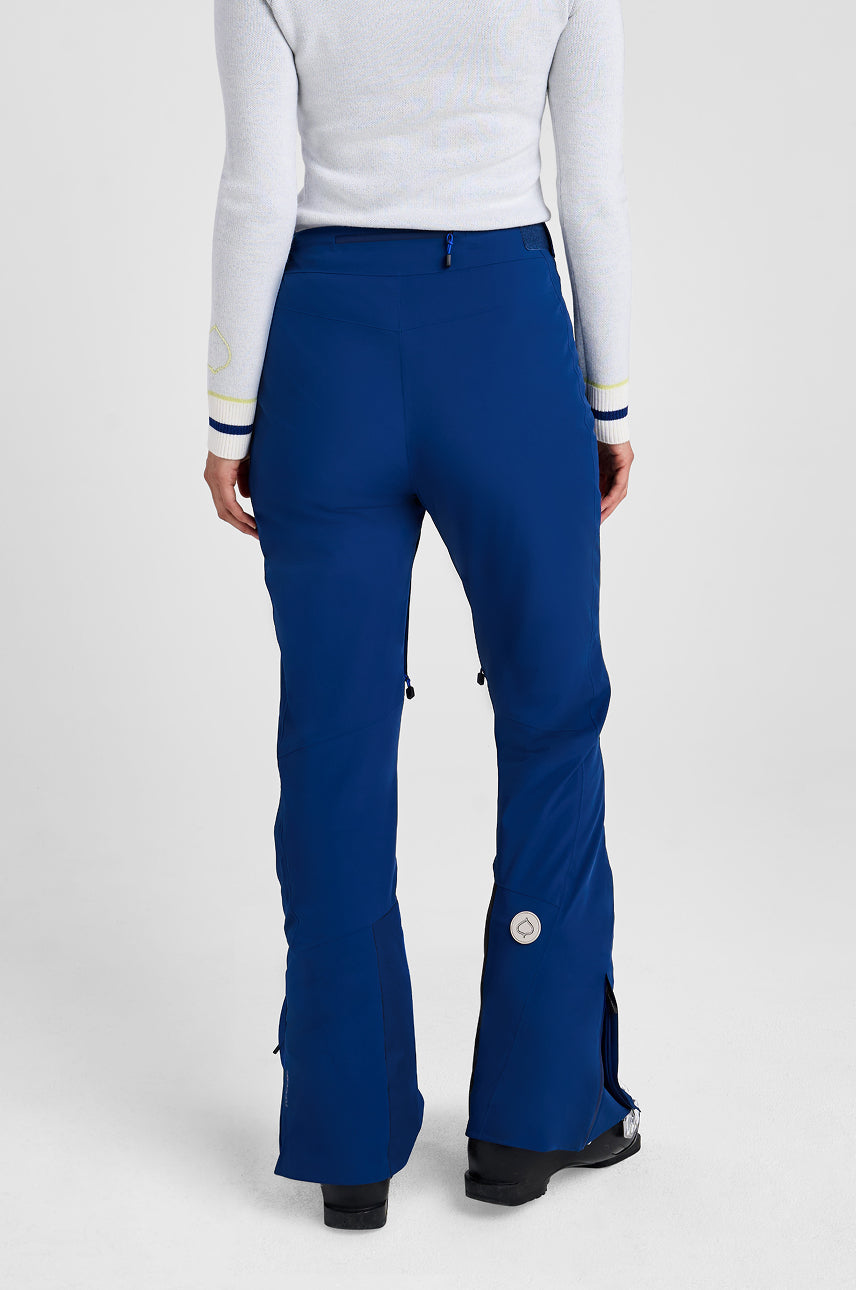 Person wearing blue pants and a white top on a light gray background